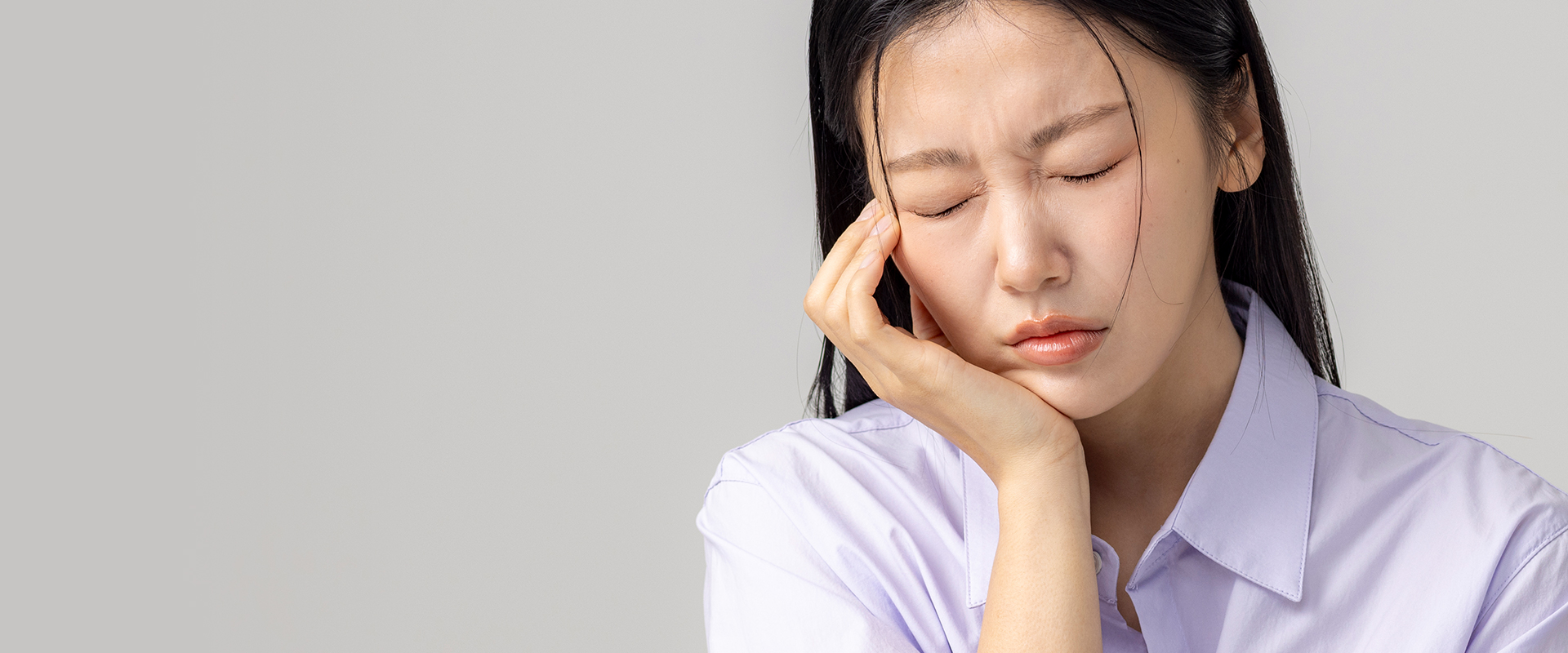 턱 통증으로 얼굴을 감싸며 괴로워하는 여성 - 턱관절치료 전경 이미지