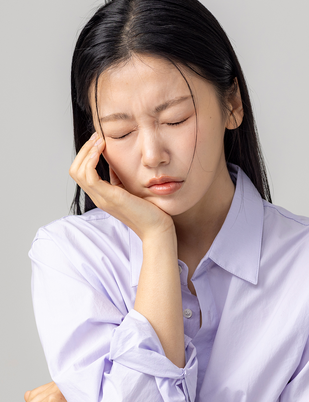 턱 통증으로 얼굴을 감싸며 괴로워하는 여성 - 턱관절치료 전경 이미지
