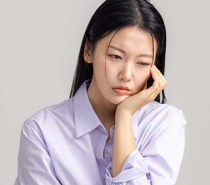 턱 통증과 관절 소리를 호소하며 얼굴을 짚고 있는 환자 모습